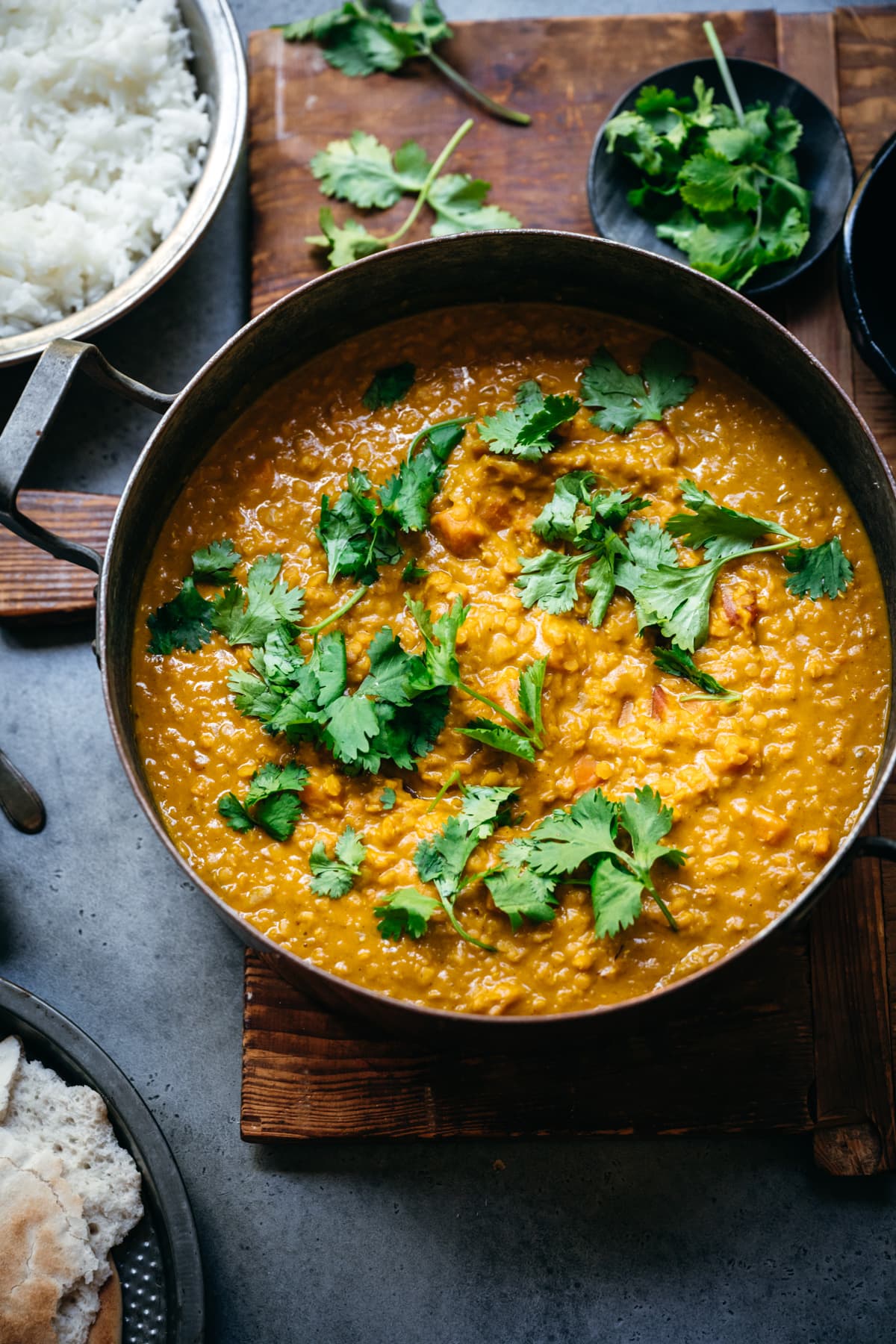 overhead view of a large pot of vegan masoor dal topped with fresh cilantro.