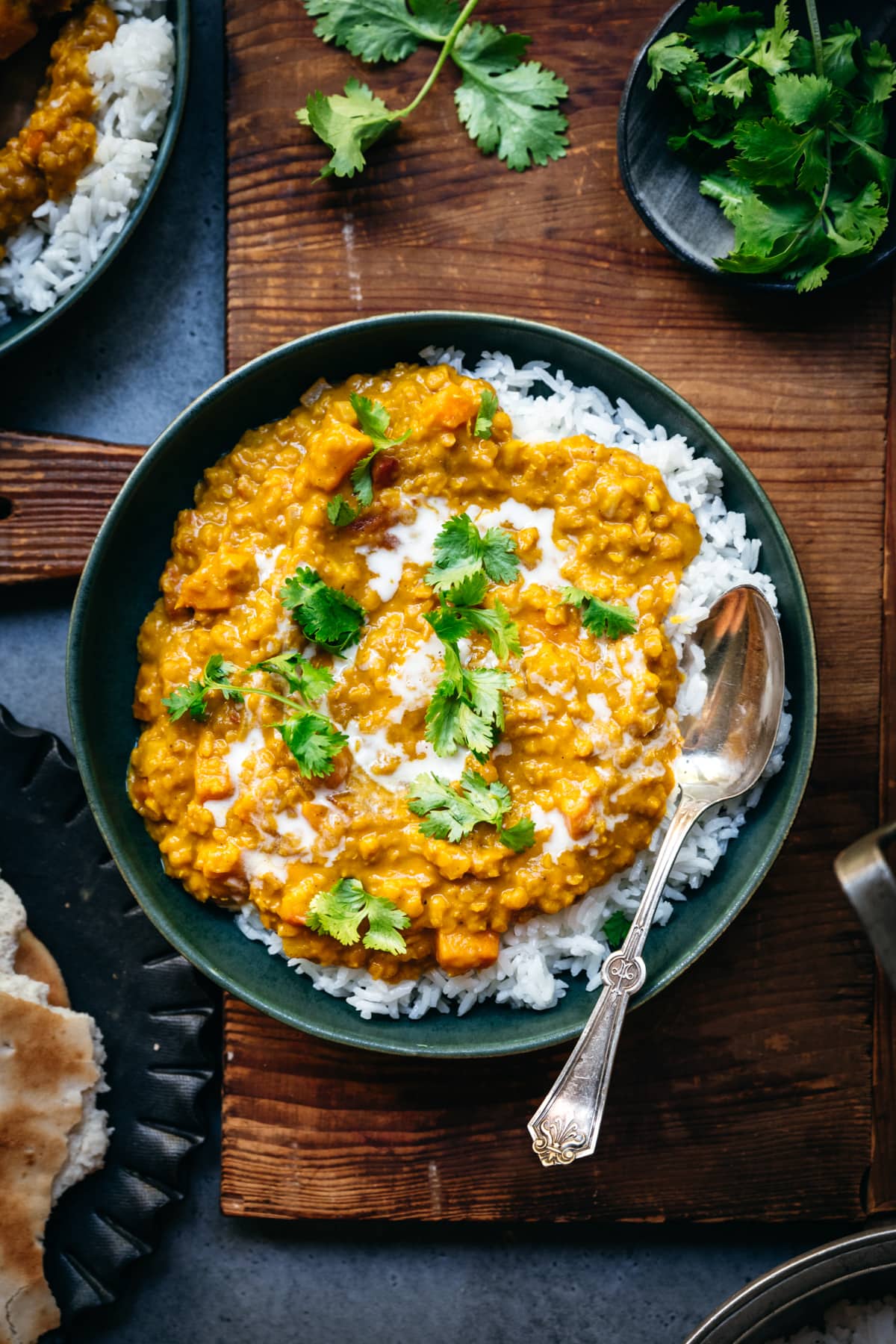 overhead view of bowl with white rice and vegan red lentil dal toped with fresh cilantro.