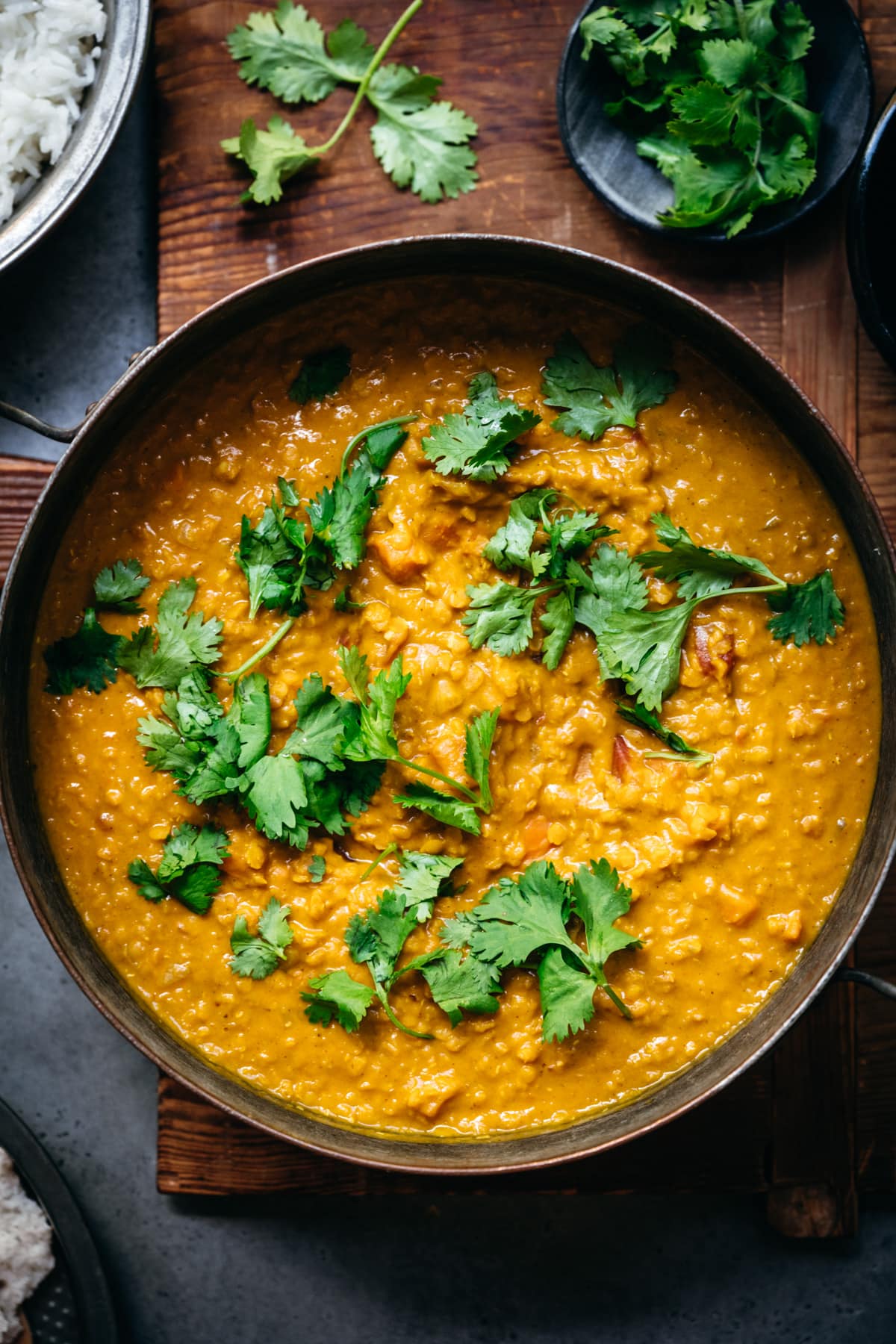 overhead view of a large pot of vegan masoor dal topped with fresh cilantro.