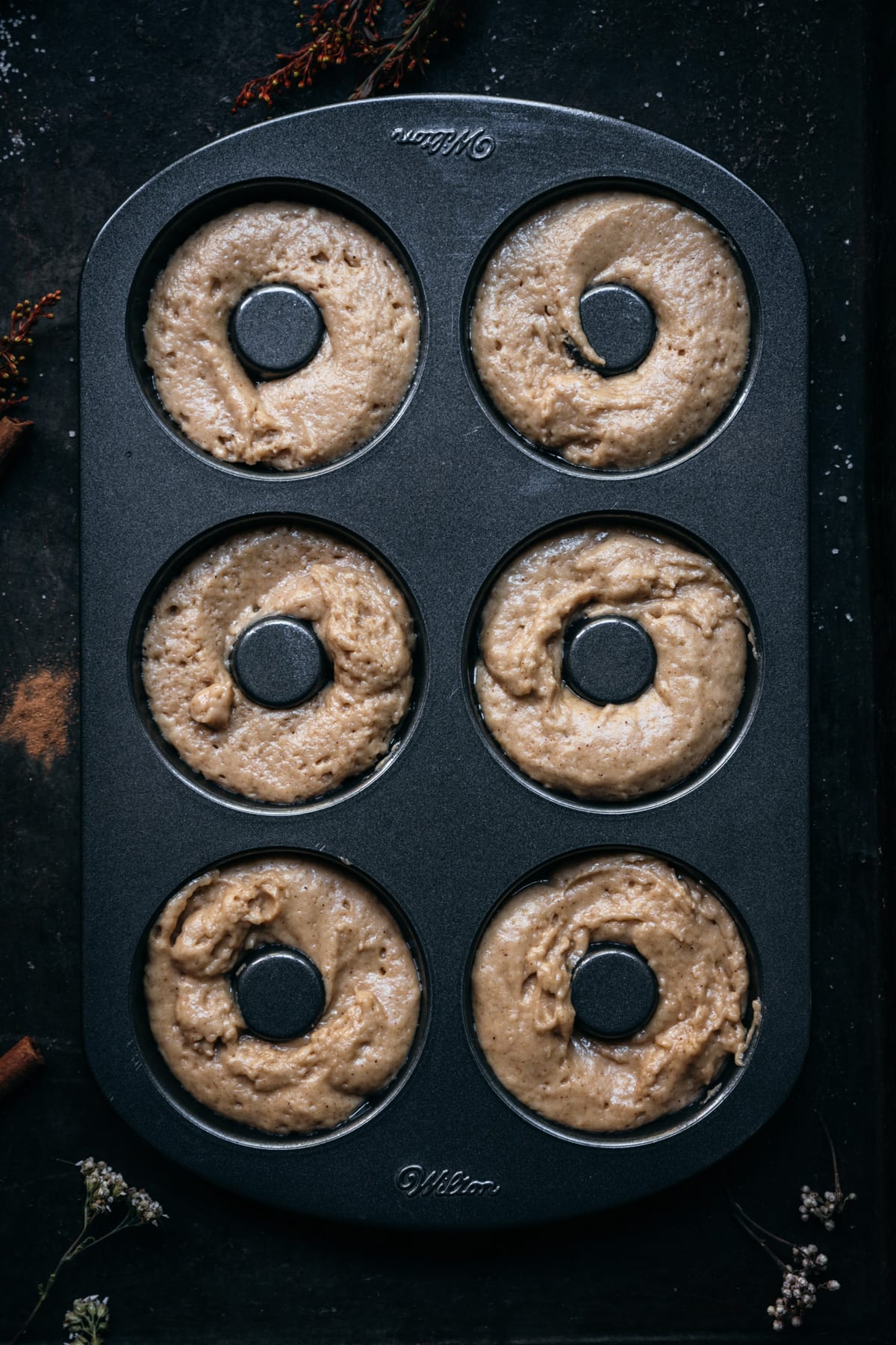 overhead view of donut pan filled with apple cider donut batter.