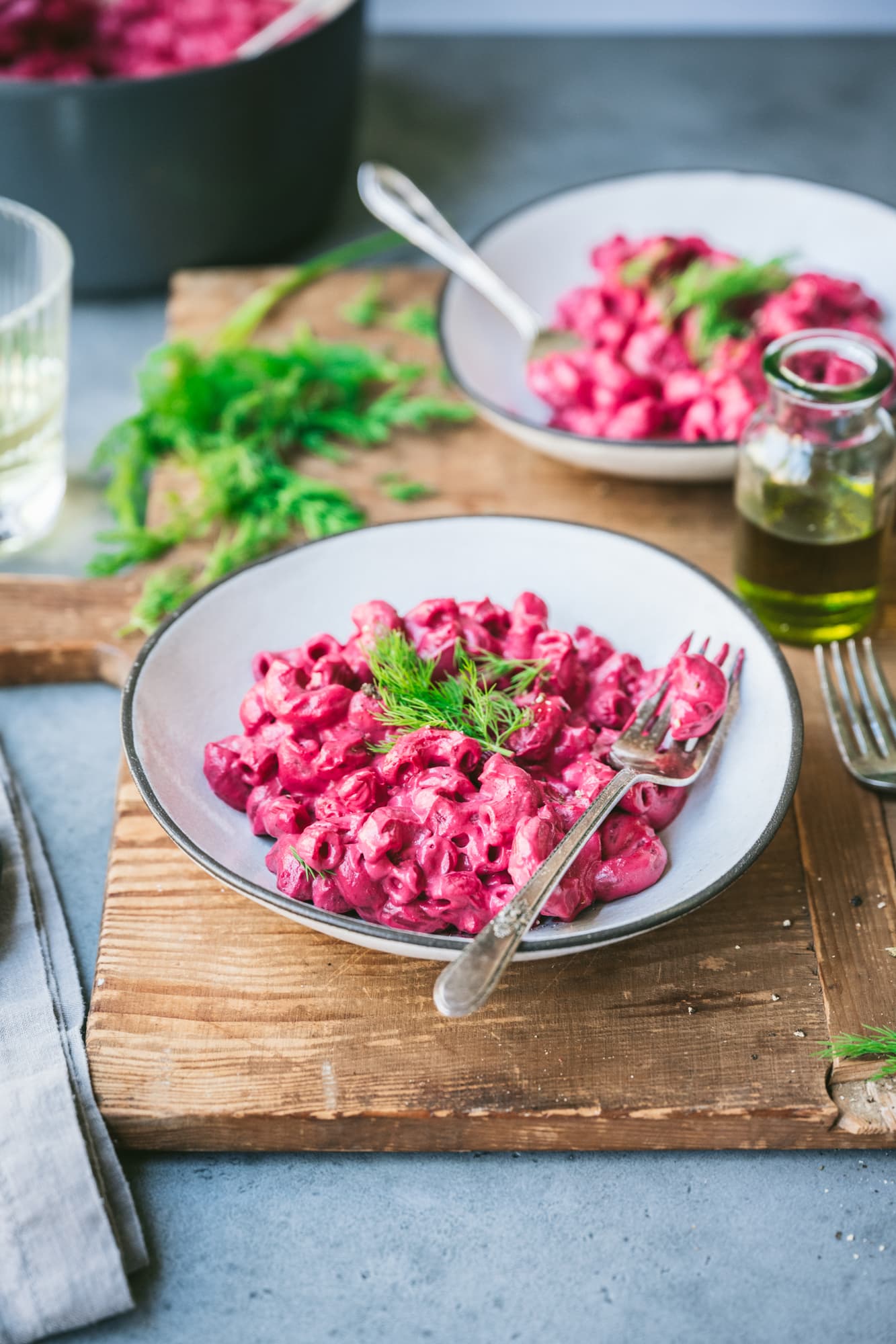 side view of vegan beet pasta in a white bowl with fork.