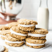 side view of stack of carrot cake sandwich cookies with cream cheese frosting.