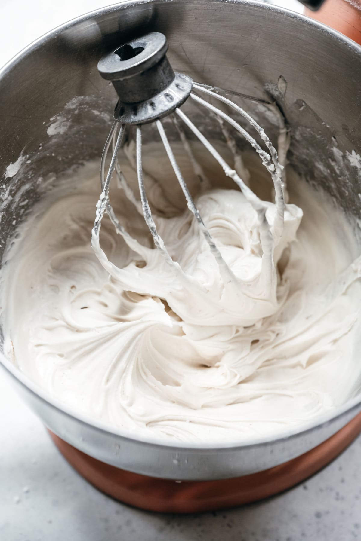 close up view of vegan cream cheese frosting in mixing bowl.