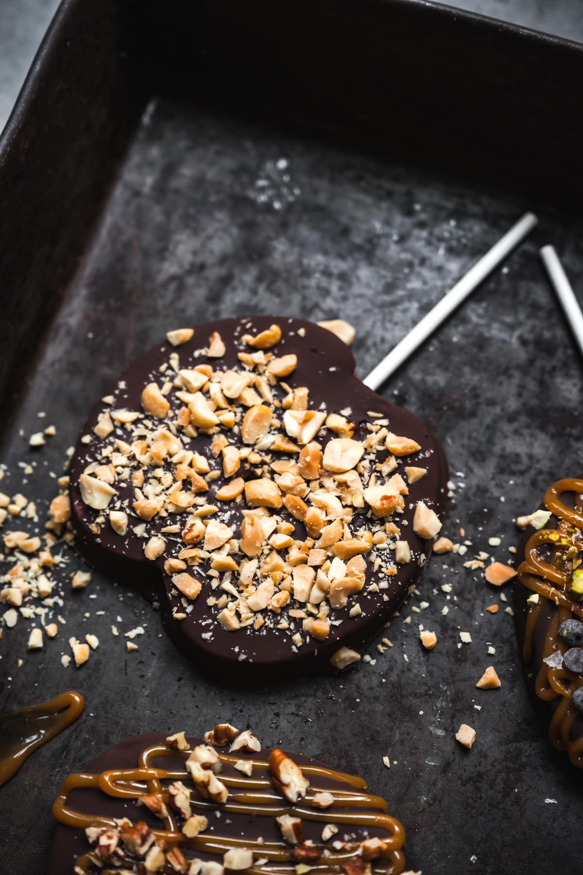 overhead view of chocolate covered apple slice with crushed peanuts. 