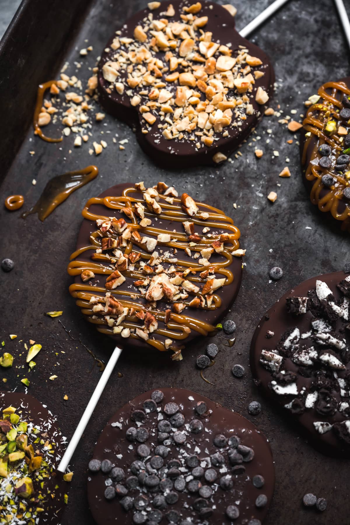 close up view of chocolate covered apple slice with caramel and pecans. 