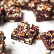 side view of a square of vegan fudge with nuts and cranberries.