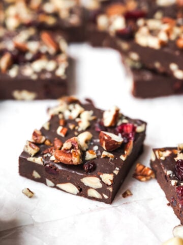 side view of a square of vegan fudge with nuts and cranberries.