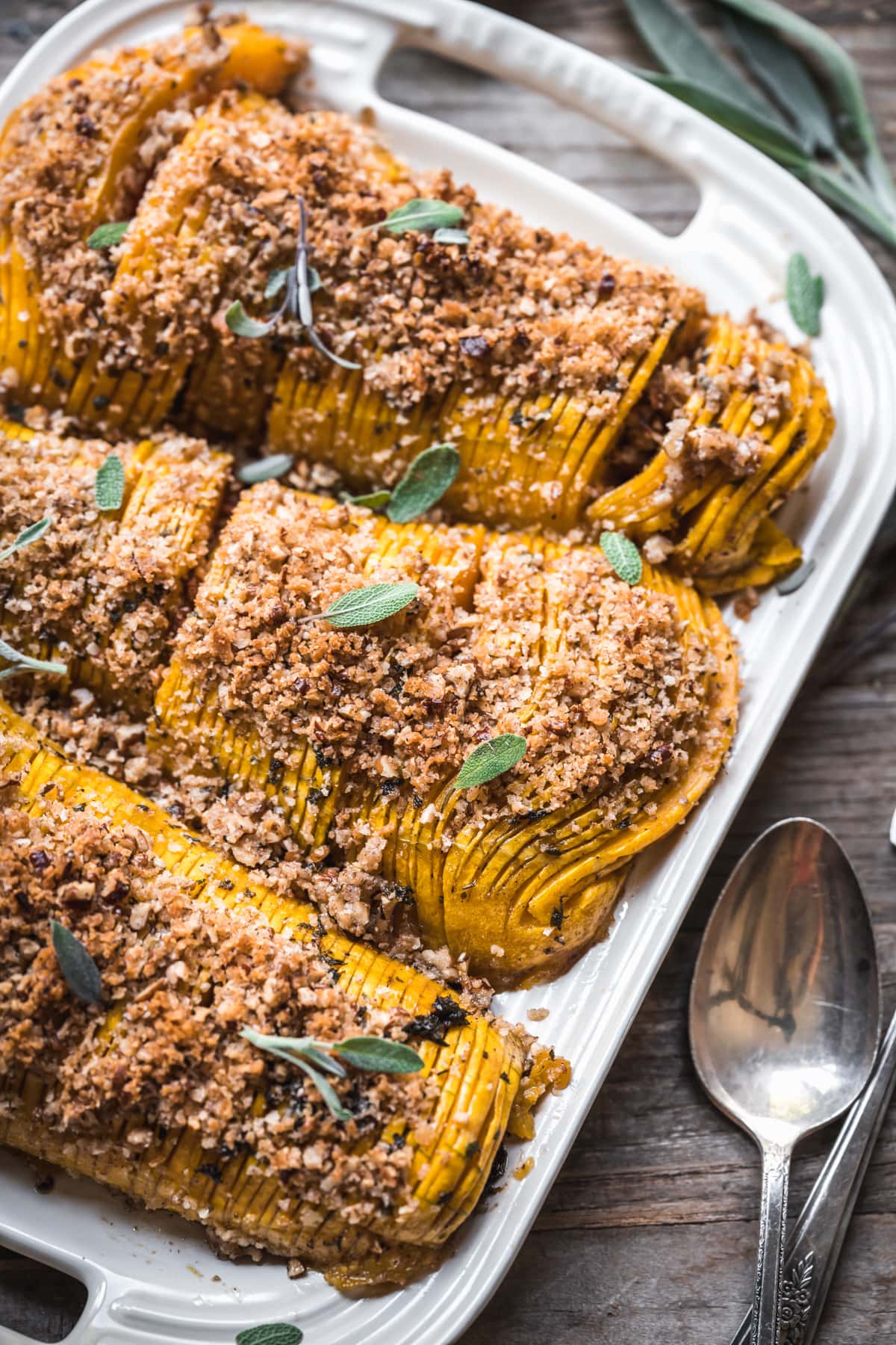 close up view of hasselback butternut squash topped with breadcrumbs. 