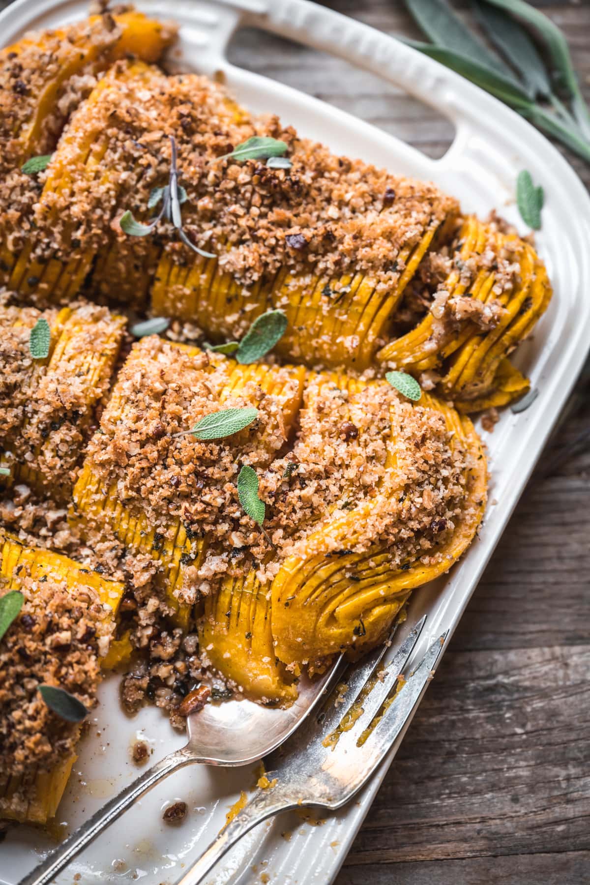 close up view of vegan hasselback butternut squash with breadcrumbs. 