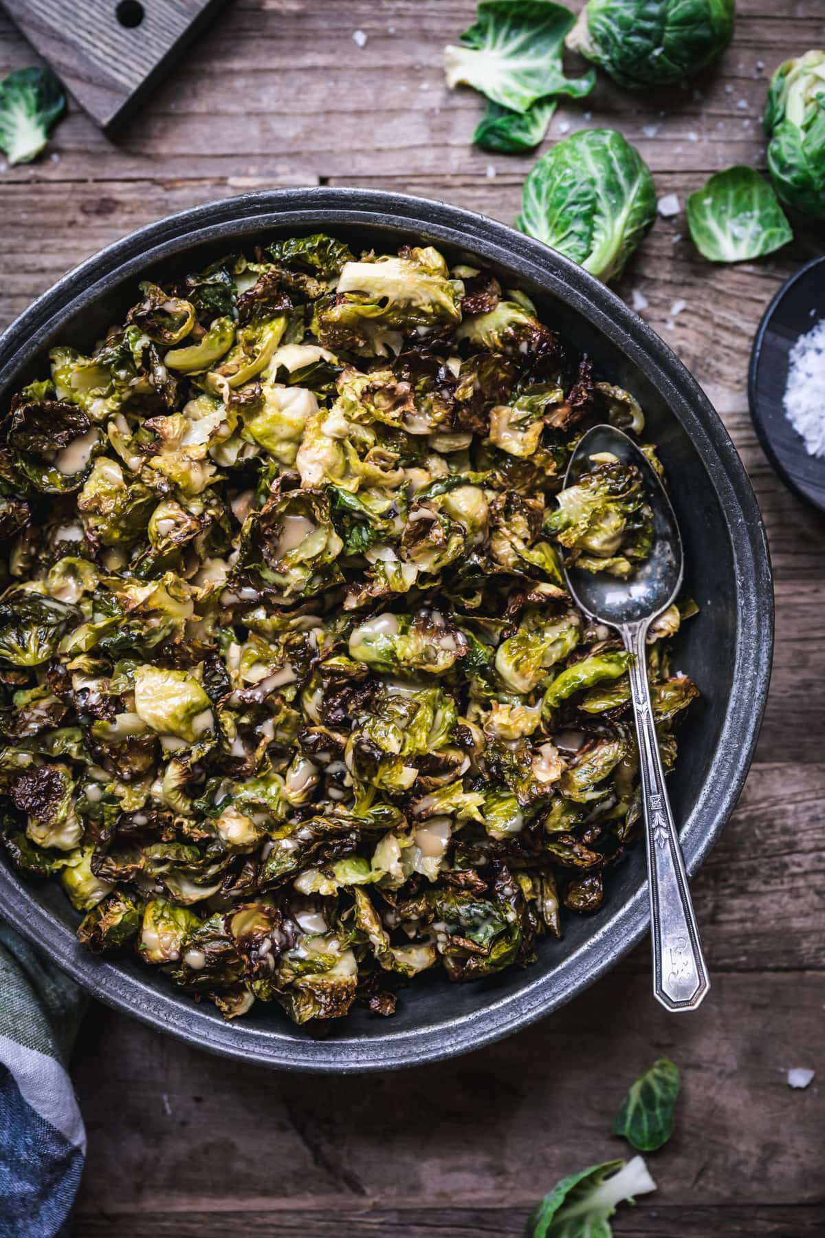 overhead view of a bowl of crispy roasted brussels sprouts with maple mustard dressing.