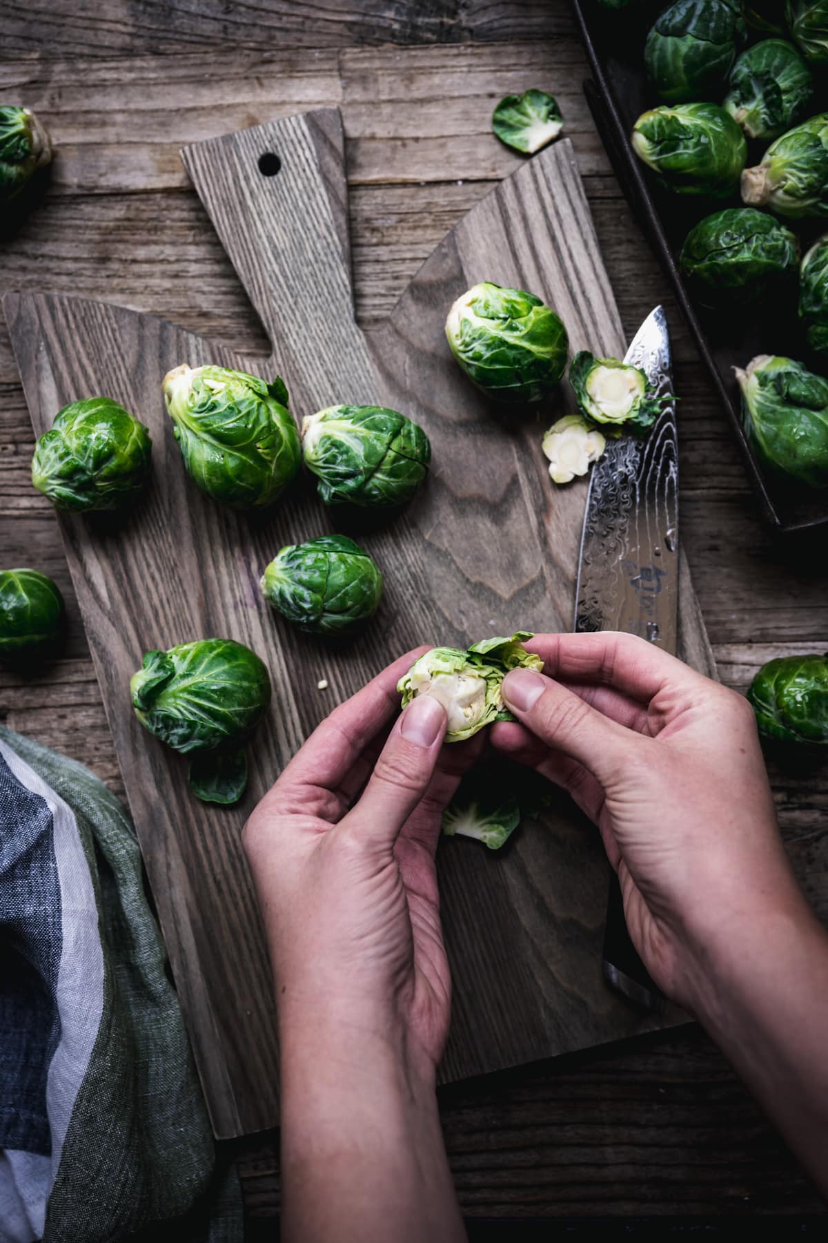 overhead view of person peeling leaves form a brussels sprout.