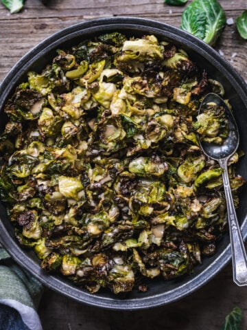 overhead view of a bowl of crispy roasted brussels sprouts with maple mustard dressing.