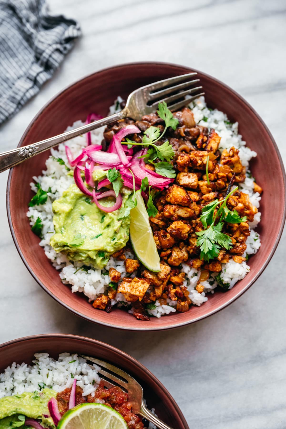 overhead view of vegan burrito bowl with sofritas tofu, guacamole and rice.