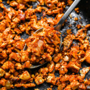 Close up view of sofritas tofu in a skillet with a serving spoon.