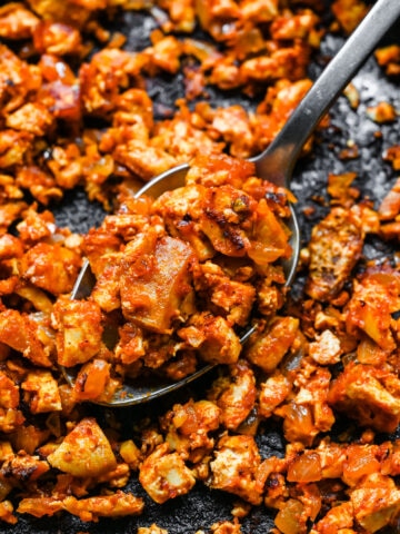 Close up view of sofritas tofu in a skillet with a serving spoon.