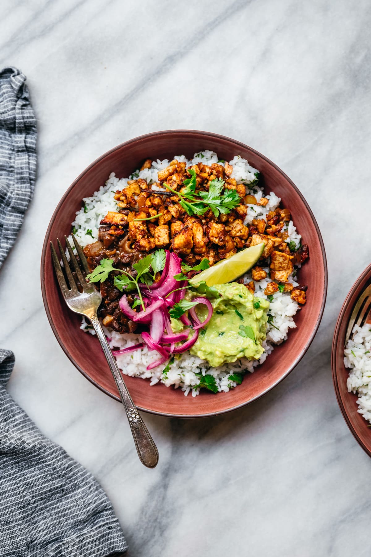 overhead view of vegan burrito bowl with sofritas tofu, guacamole and rice.