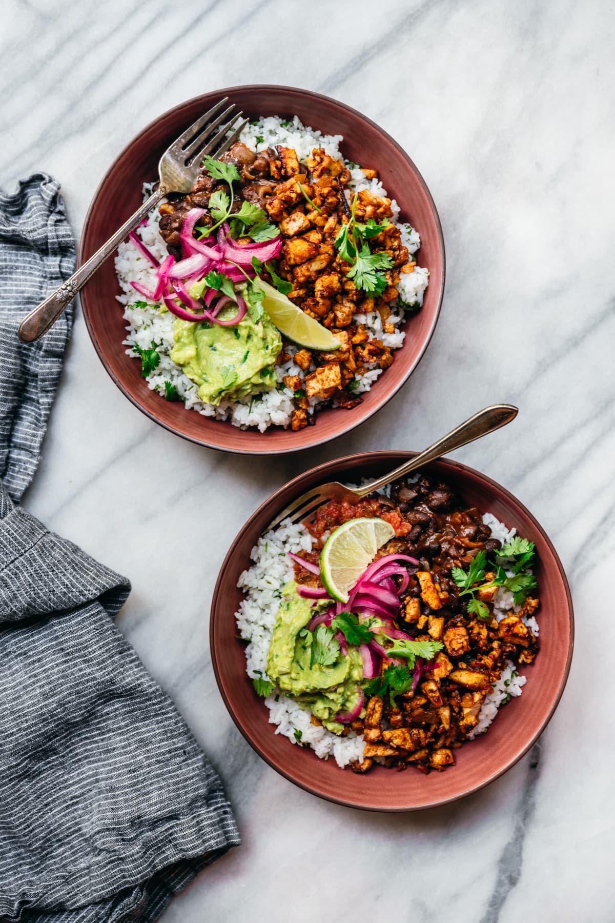 overhead view of two vegan burrito bowls with sofritas tofu, guacamole and rice.