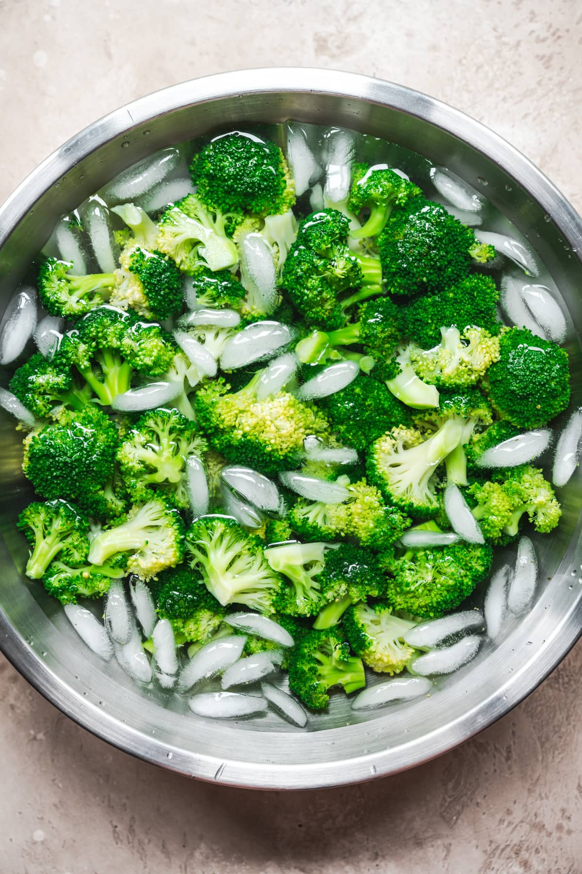 overhead view of cooked broccoli in ice water.