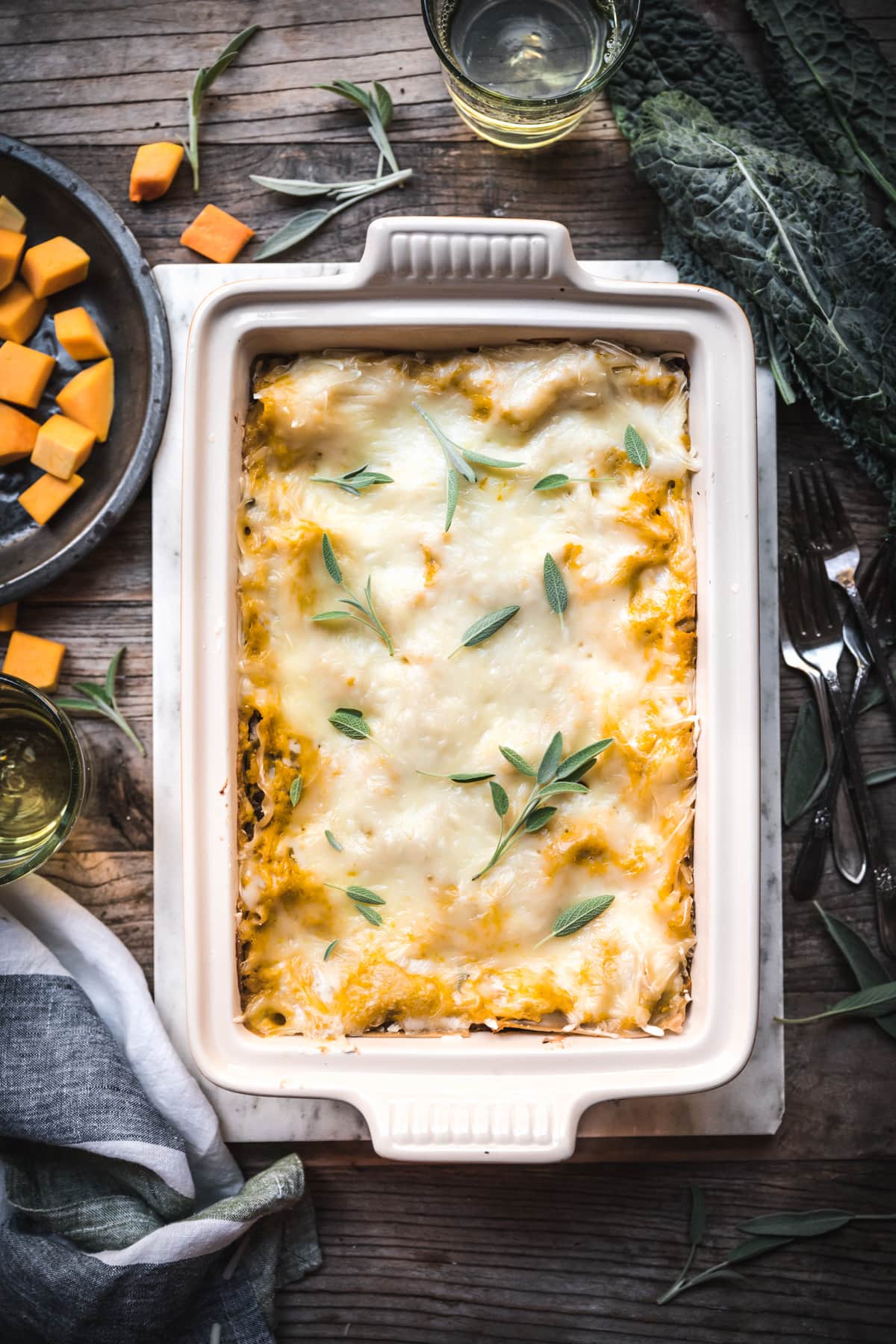 overhead view of pan over vegan butternut squash lasagna on wood table.