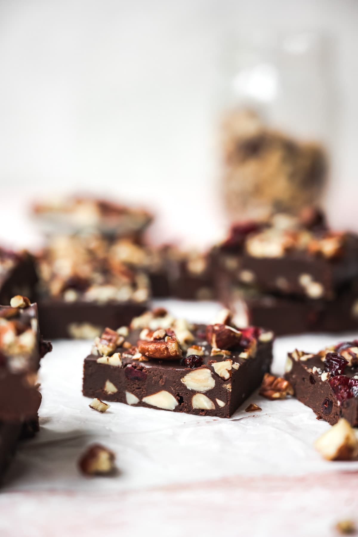 side view of a square of vegan fudge with nuts and cranberries. 