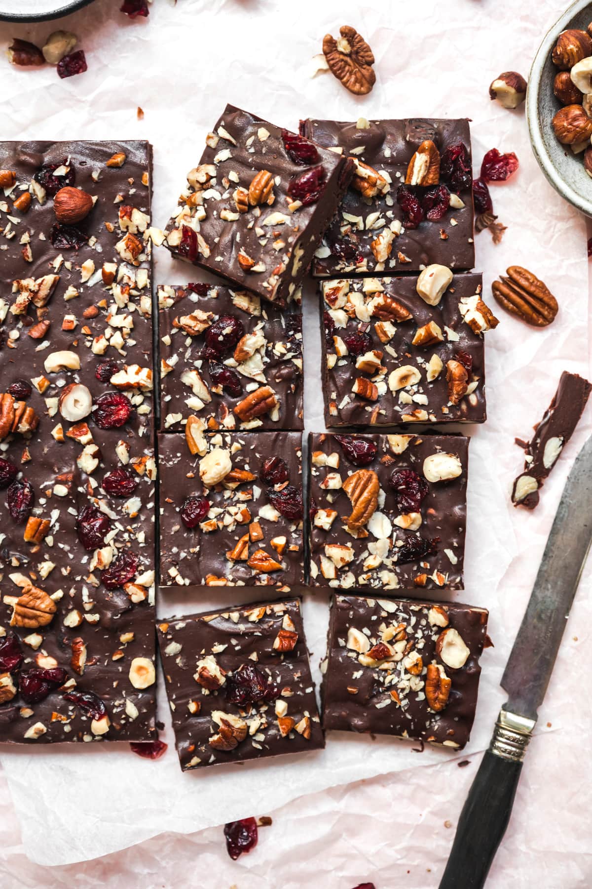 overhead view of vegan cranberry nut fudge sliced into squares on parchment paper. 