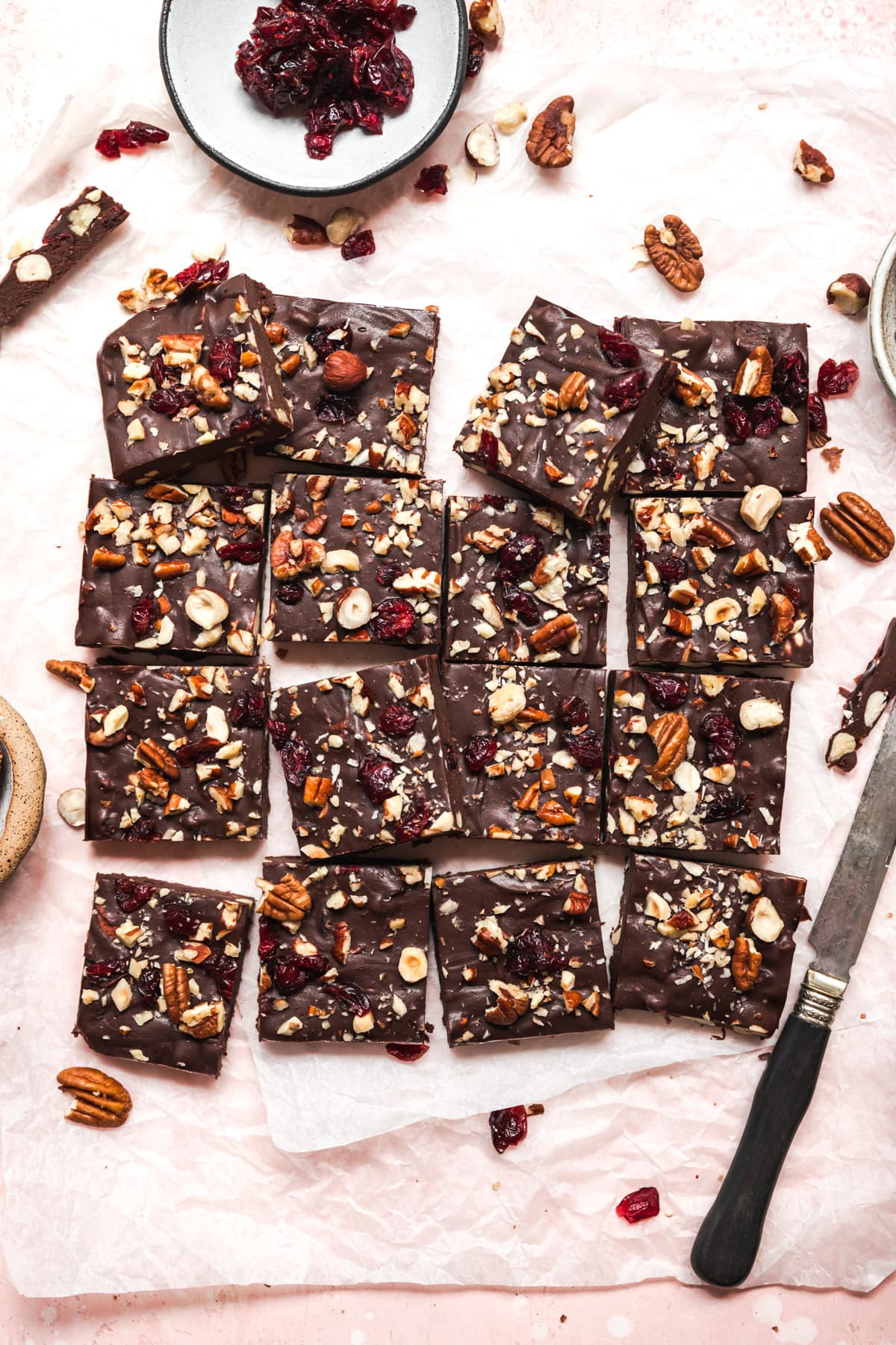 overhead view of vegan cranberry nut fudge sliced into squares on parchment paper. 