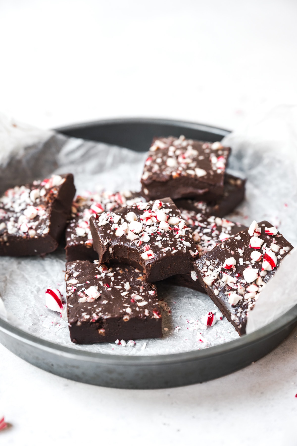 side view of circular pan filled with slices of vegan peppermint fudge. 