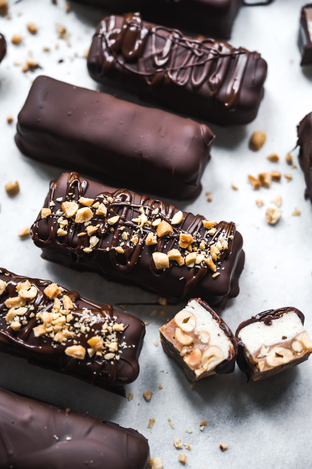 overhead view of homemade vegan snickers bars on parchment paper. 