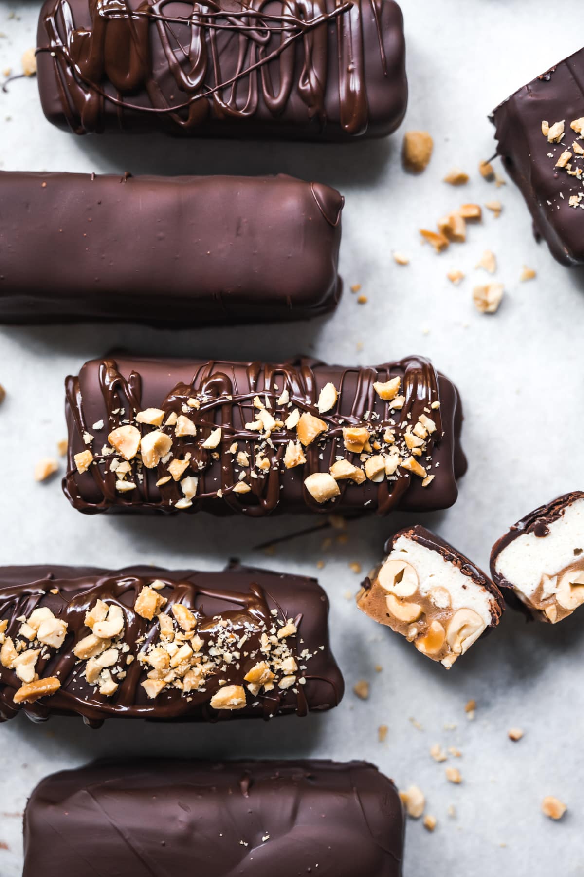 overhead view of homemade vegan snickers bars on parchment paper. 