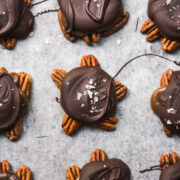 overhead view of vegan chocolate caramel pecan turtles on parchment paper.