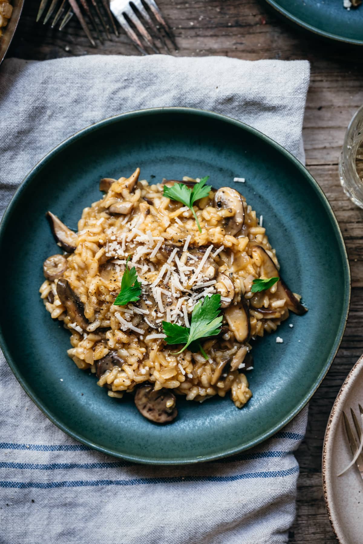 close up view of vegan mushroom risotto on blue plate.