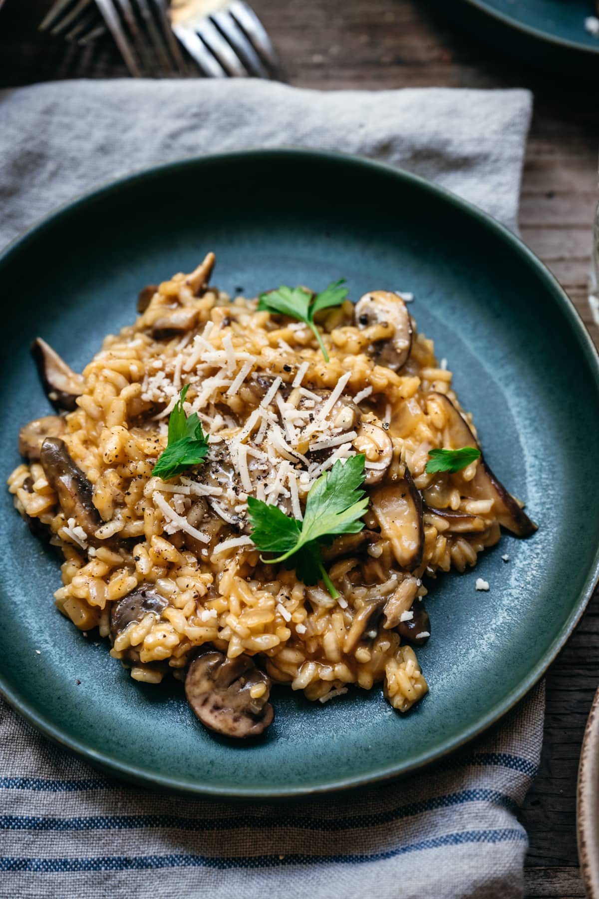 close up view of vegan mushroom risotto on blue plate.