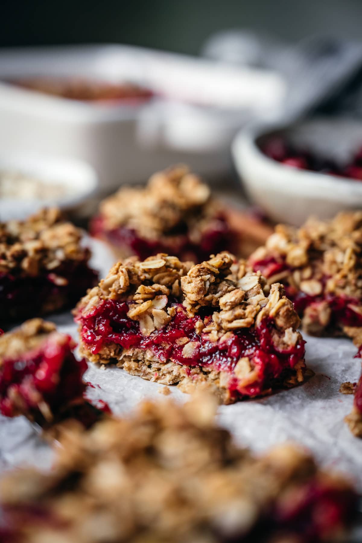 side view of vegan cranberry crumb bar cut in half with oat streusel topping.