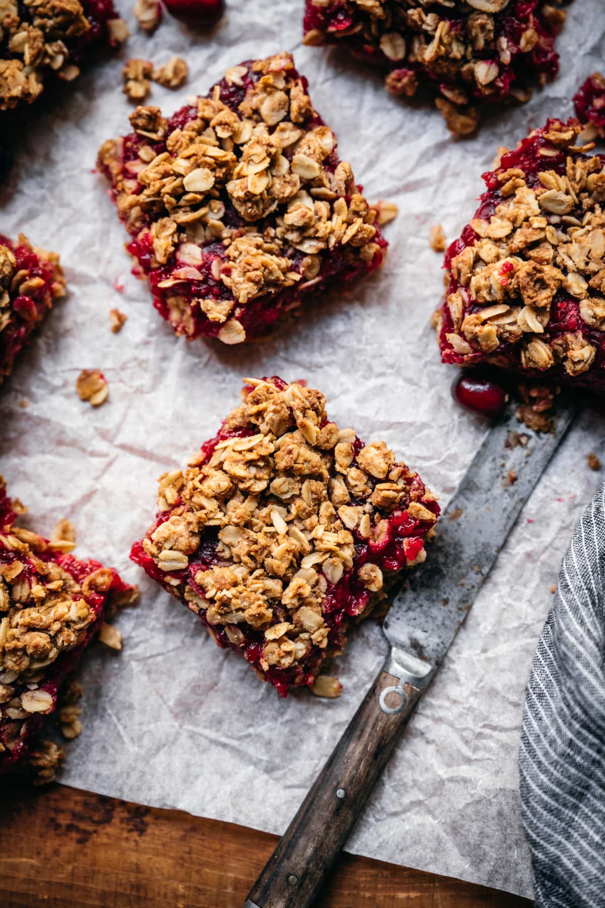 overhead view of slices of cranberry crumb bars on parchment paper