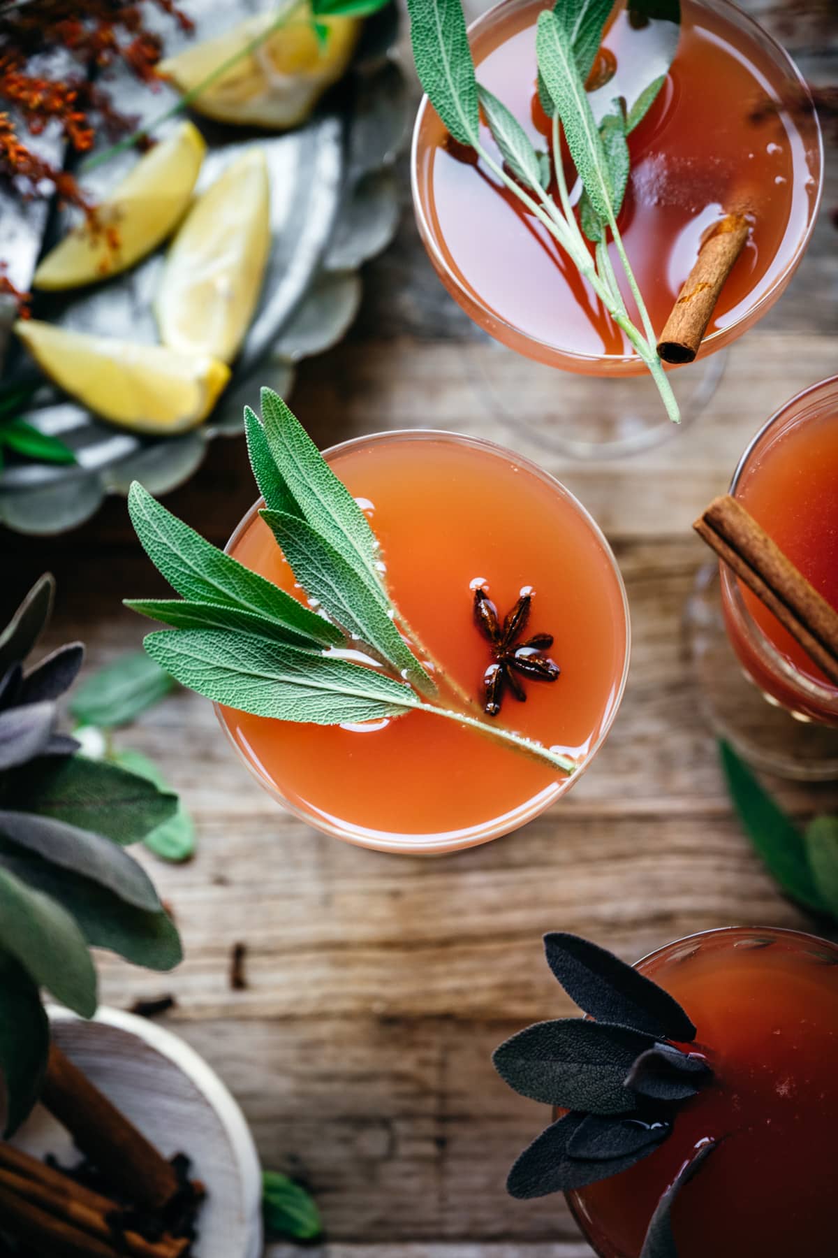 overhead view of cranberry orange mimosas garnished with fresh sage.