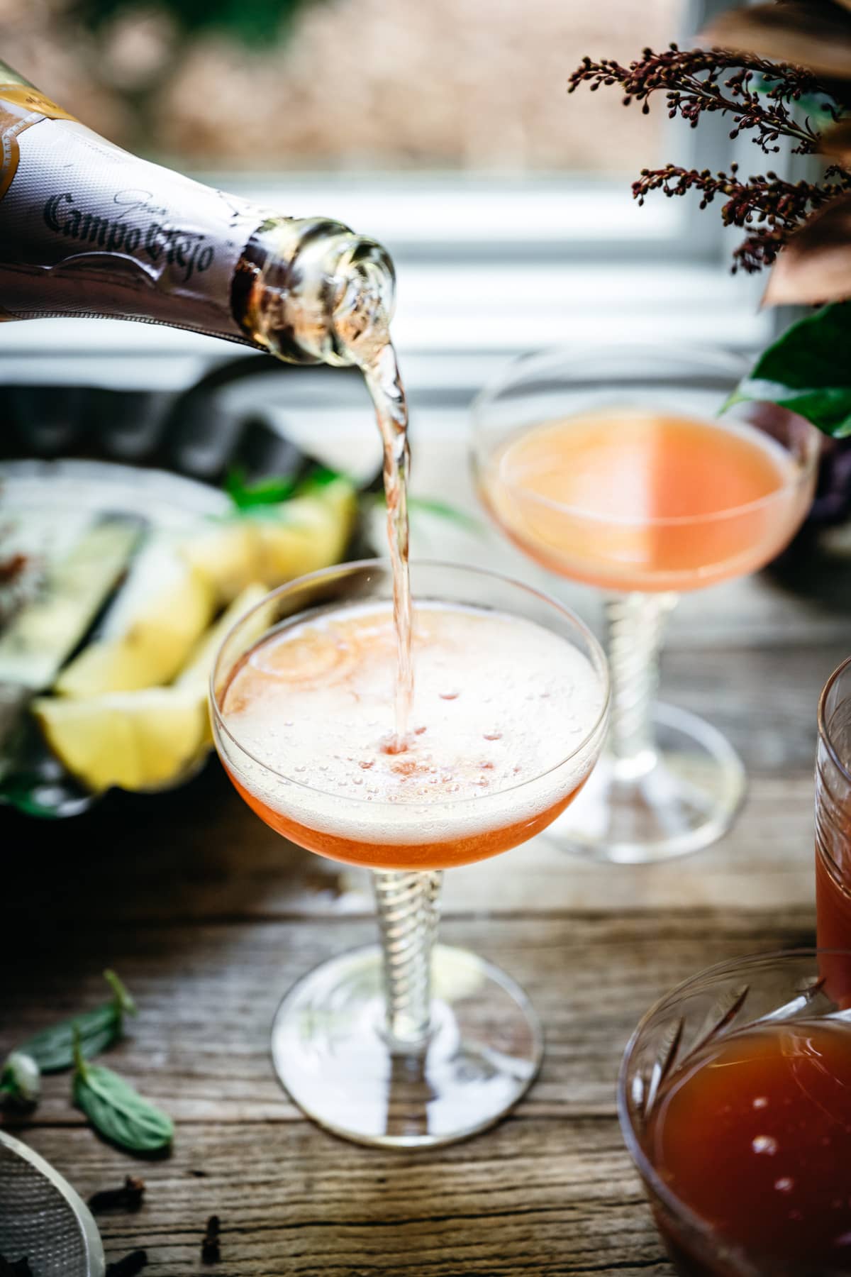 pouring sparkling wine into cranberry orange mimosa.