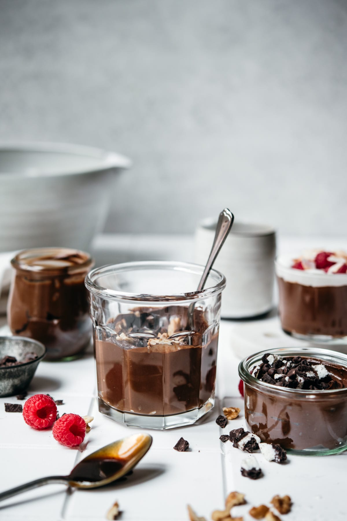 side view of vegan avocado chocolate mousse in glass jars. 