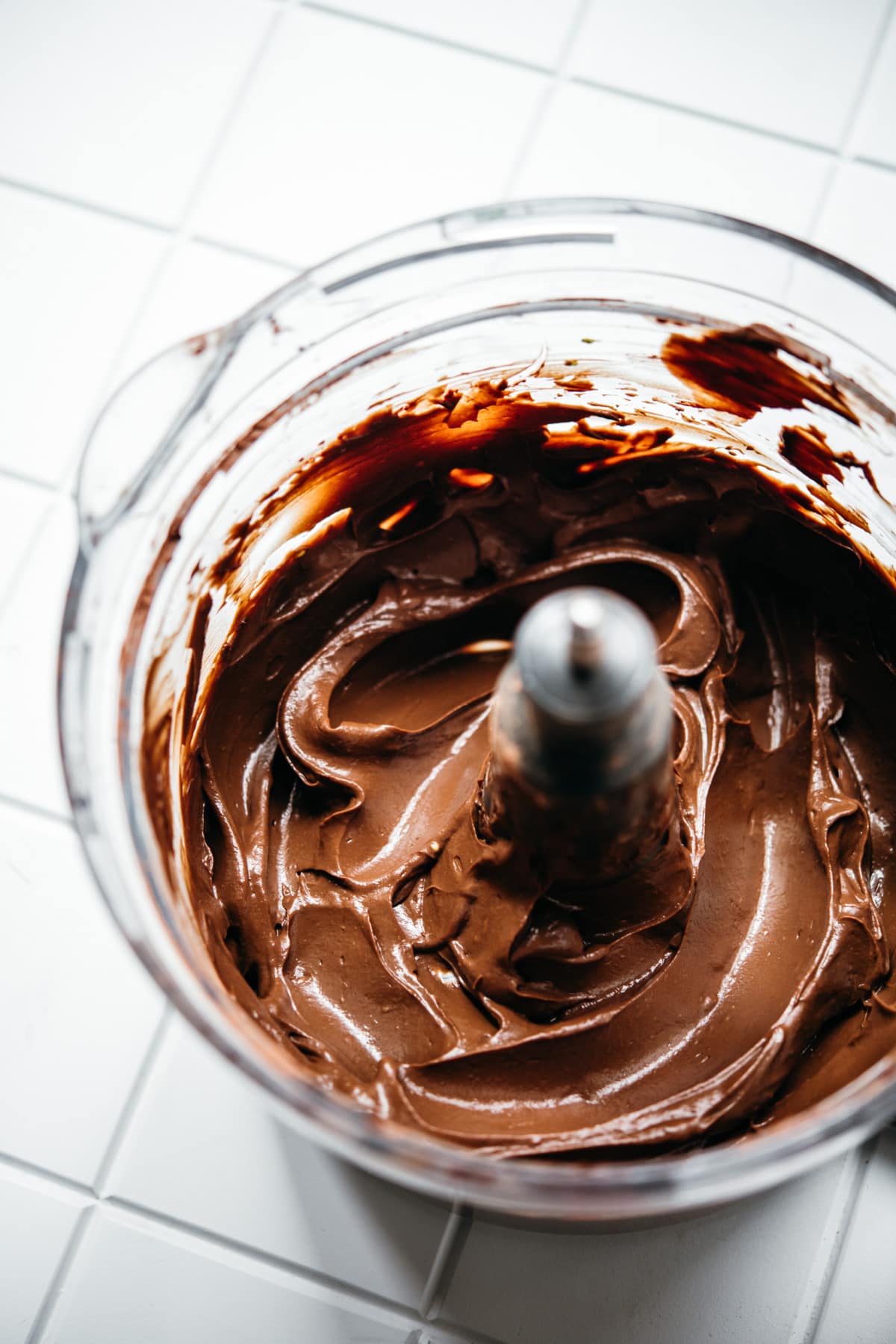 close up side view of silky smooth chocolate mousse in food processor.