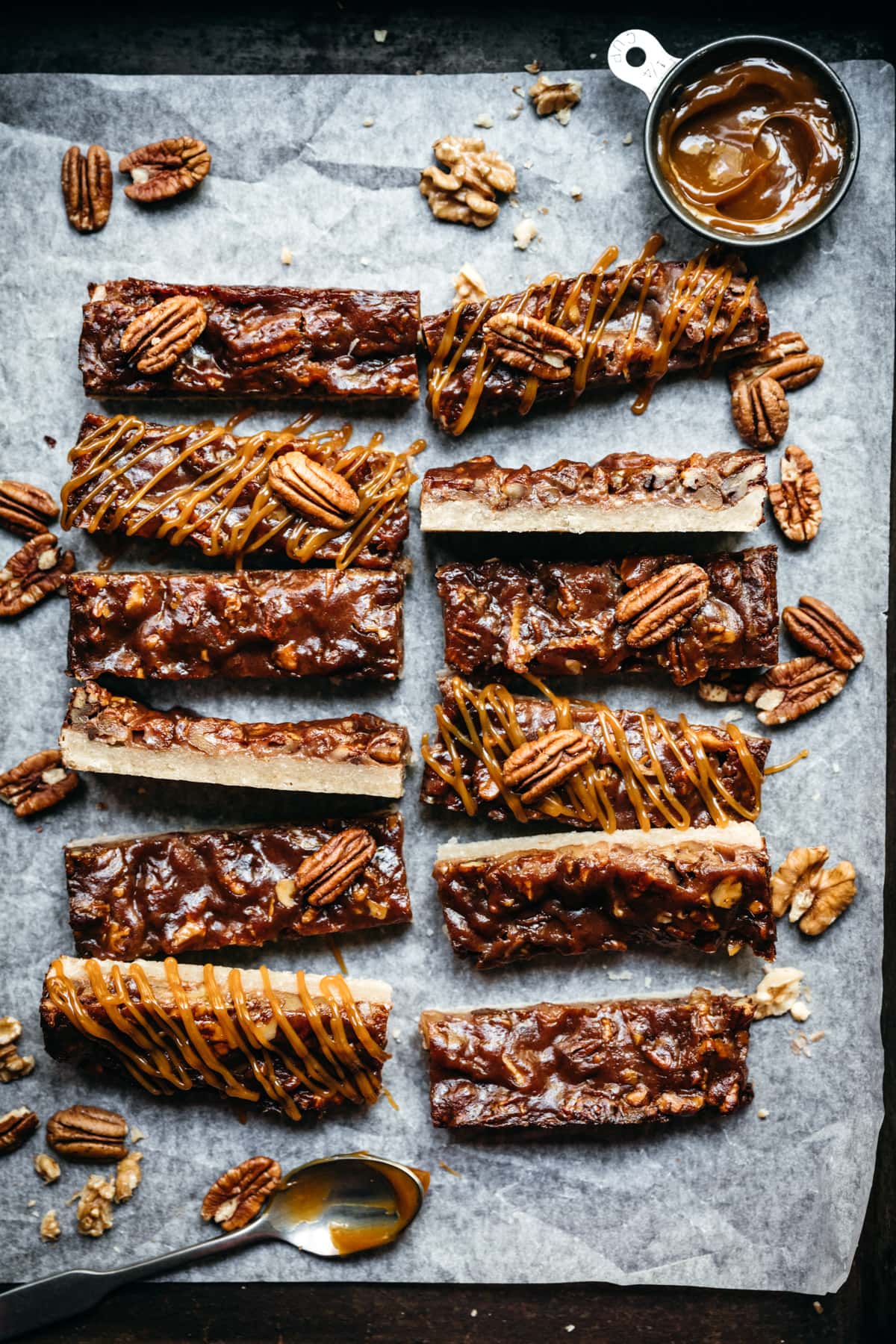 overhead view of maple bourbon pecan pie bars sliced on parchment paper.