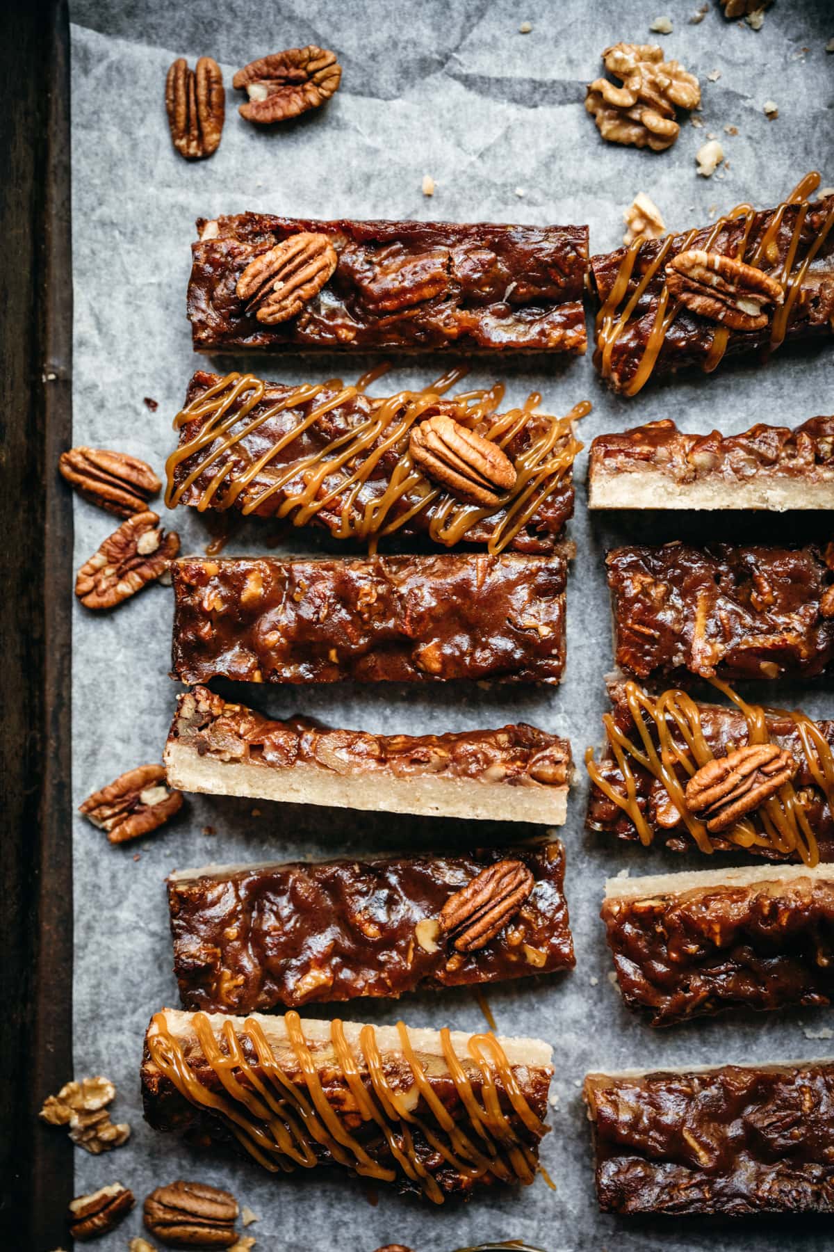 overhead view of maple bourbon pecan pie bars sliced on parchment paper.