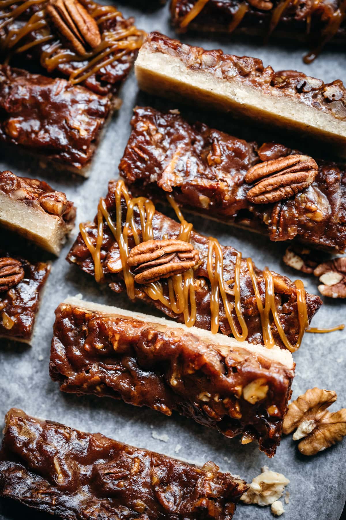 overhead view of maple bourbon pecan pie bars sliced on parchment paper.
