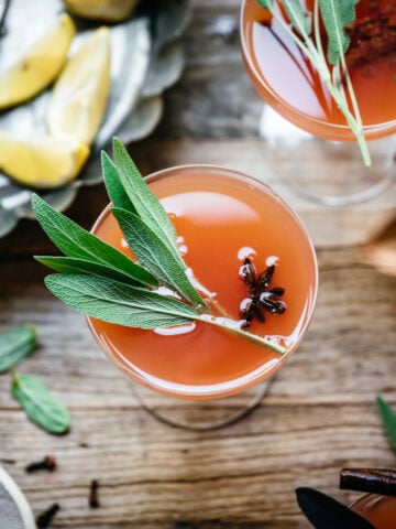 overhead view of cranberry orange mimosas garnished with fresh sage.