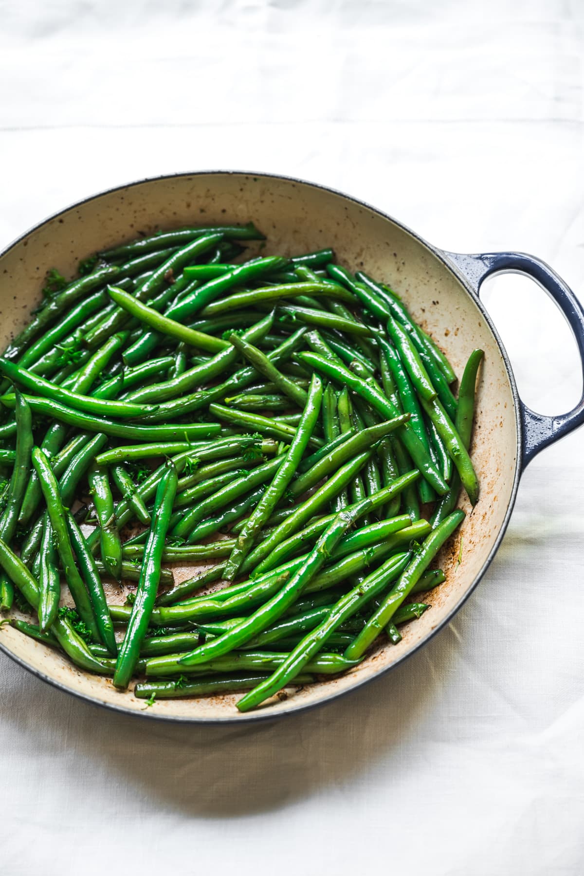 side view of sautéed green beans in a pan.
