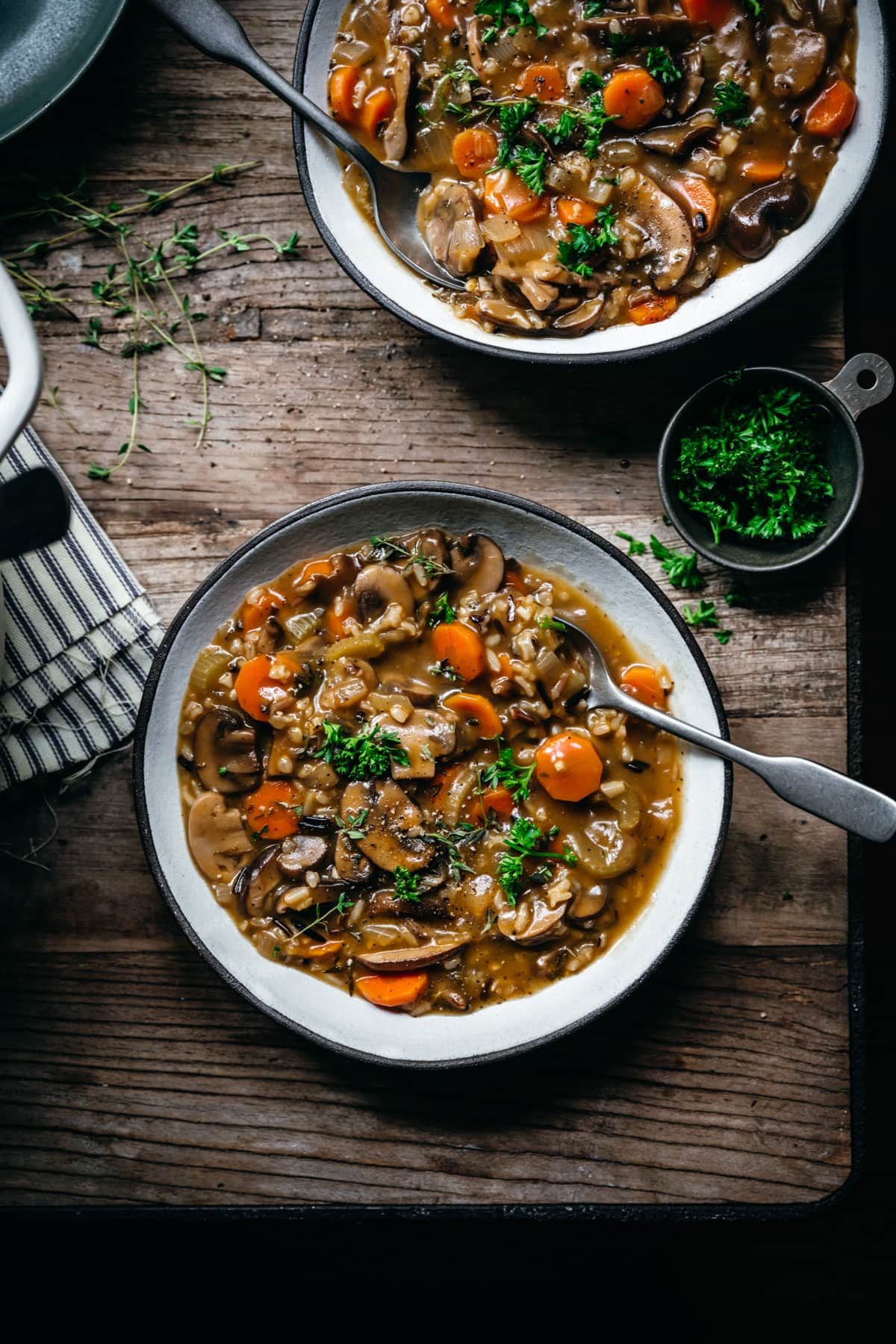 overhead view of vegan wild rice mushroom soup in a bowl on wood table. 