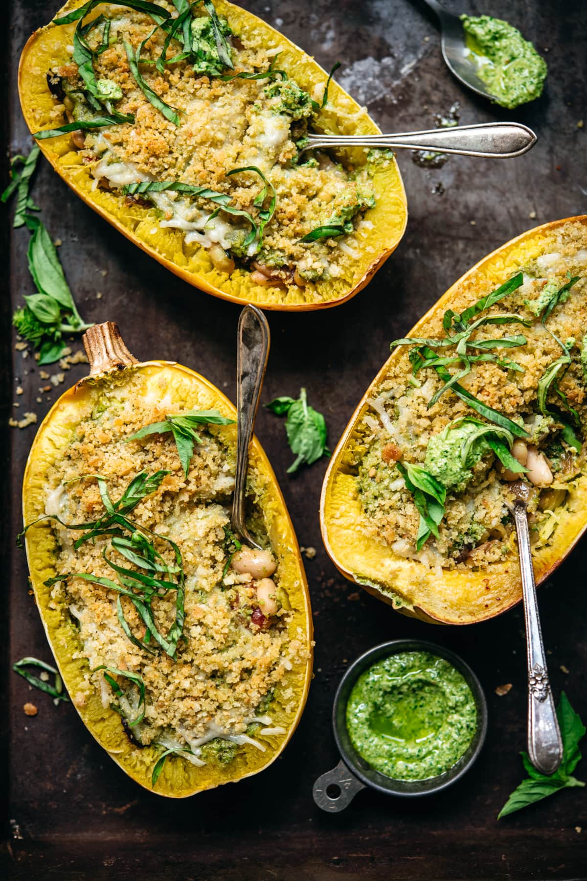 overhead view of spaghetti squash filled with pesto, white beans and topped with breadcrumbs.