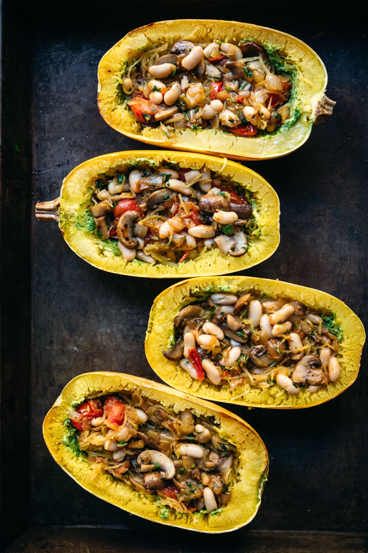 Four spaghetti squash filled with white beans, mushrooms and tomatoes.