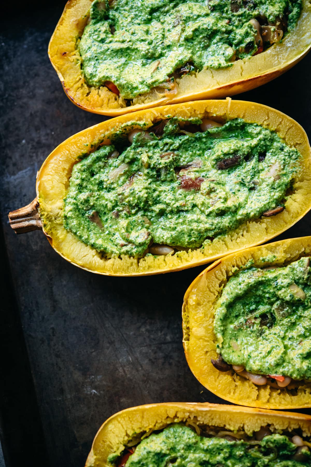 close up of spaghetti squash with mushroom filling and pesto on top.