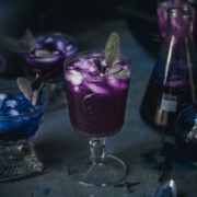side view of a purple polyjuice potion cocktail in a glass.