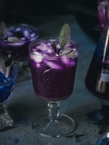 side view of a purple polyjuice potion cocktail in a glass.