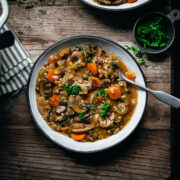 overhead view of vegan wild rice mushroom soup in a bowl on wood table.